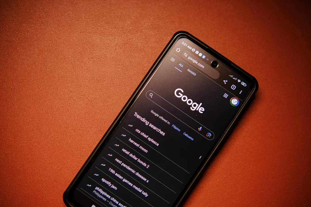 Smartphone mostrando la página de búsqueda de Google con tendencias, ilustrando los cambios en los resultados enriquecidos FAQ en Google Search