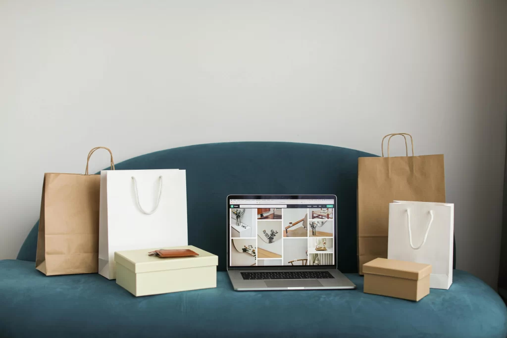 Productos y bolsas de compra de una tienda online junto a un portátil