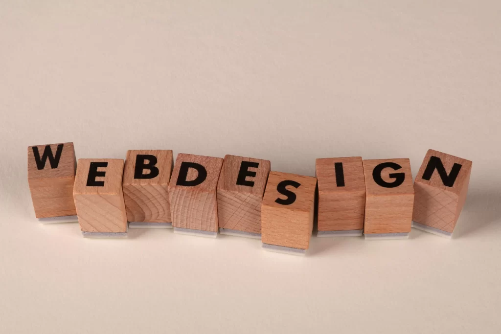 Bloques de madera con letras formando la palabra "web design", simbolizando los beneficios del rediseño web