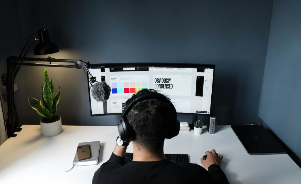 Diseñador gráfico trabajando con dos monitores en su puesto de trabajo