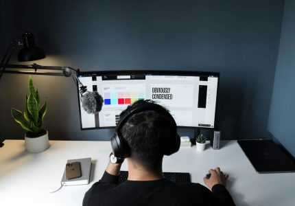 Diseñador gráfico trabajando con dos monitores en su puesto de trabajo