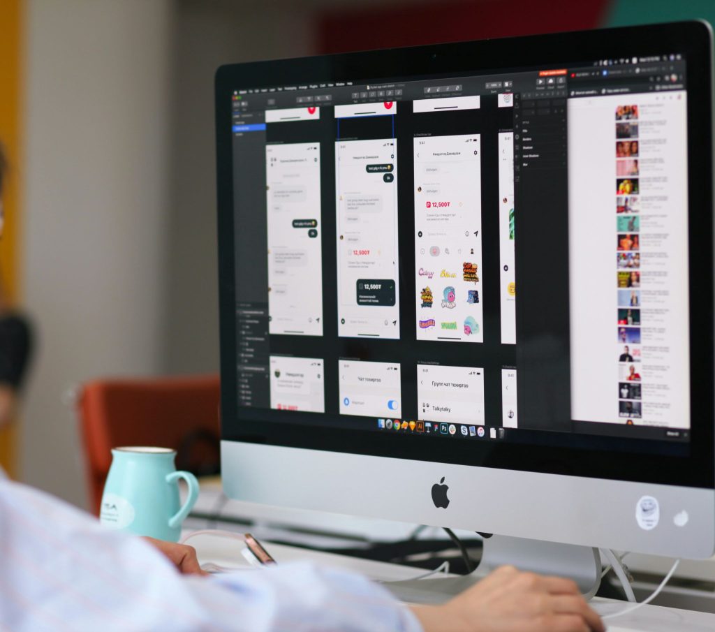 Diseñador revisando varias propuestas de composición visual en un ordenador de sobremesa