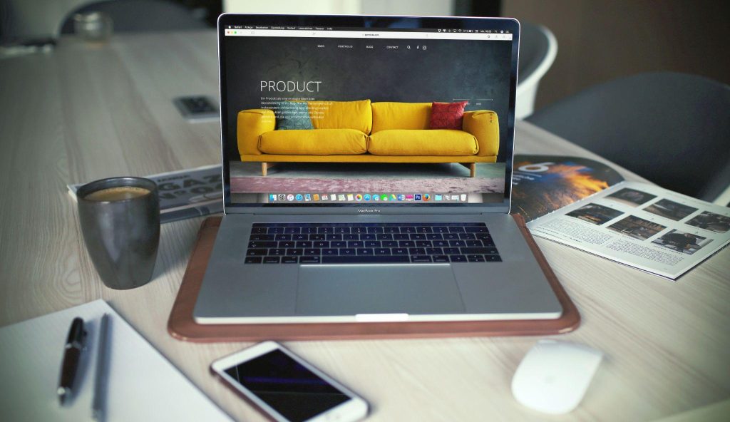 Portátil sobre un escritorio mostrando la página de producto de una tienda online con diseño limpio