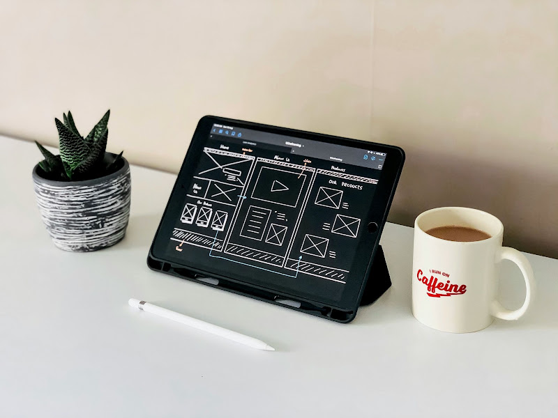 Tableta con wireframes de una landing page orientada a conversión sobre un escritorio