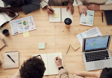 Equipo de una pyme revisando datos de gestión con portátiles y gráficos